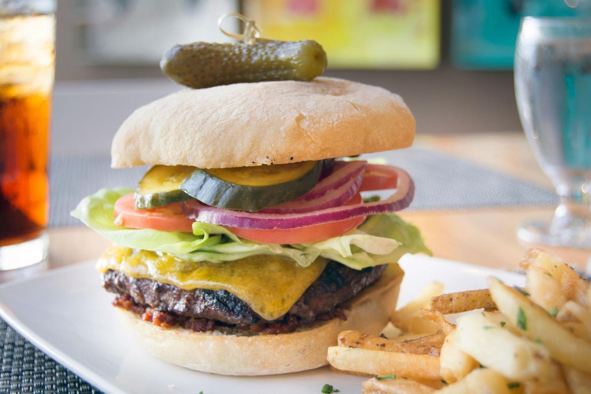 Hotel Murano Tacoma Exteriör bild A cheeseburger with lettuce, tomato, onion, and pickle